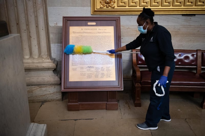 A worker cleans a copy of the Declaration of Independence at the US Capitol building. Bloomberg