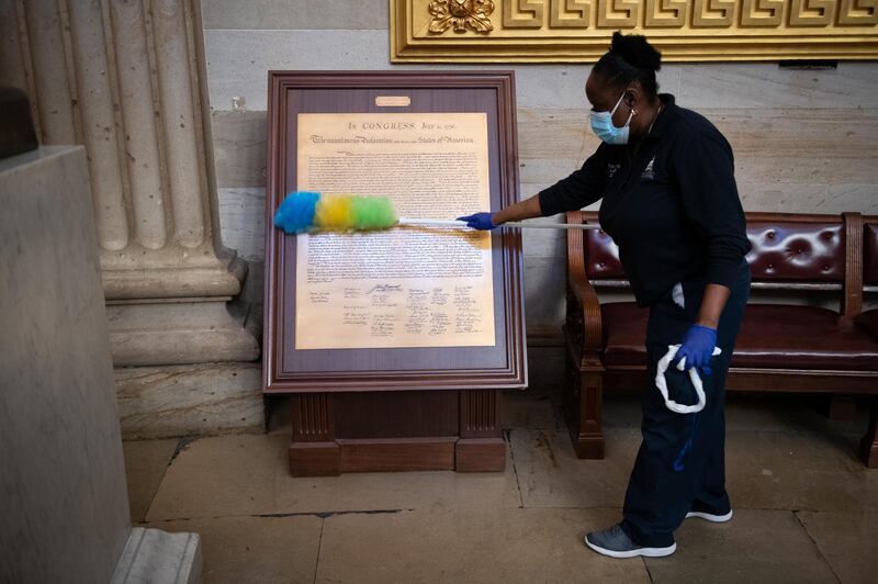 A worker cleans a copy of the Declaration of Independence at the US Capitol building. Bloomberg