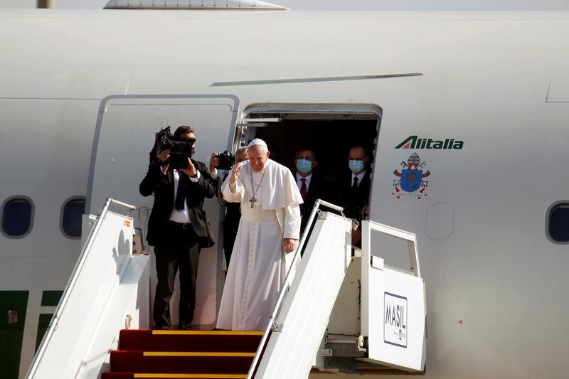 Pope Francis gestures as he boards a plane to depart for Rome, at Baghdad International Airport in Baghdad. Reuters