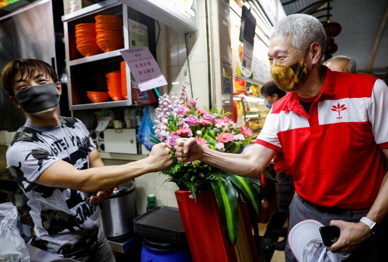 Lee Hsien Yang of the PSP greets a hawker during a walkabout ahead of the general election in Singapore on Sunday. Reuters