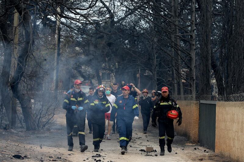 Firefighters inspect a burned area in Mati, east of Athens. AP Photo