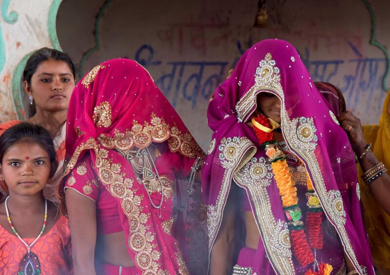 In this April 17, 2017 photo, an underaged bride, right, stands with family members during her marriage at a Hindu temple near Rajgarh, Madhya Pradesh state, India.. A significant fall in child marriages in South Asia has reduced the rate of marriage for girls globally, the U.N. children's agency said Tuesday. (AP Photo/Prakash Hatvalne)