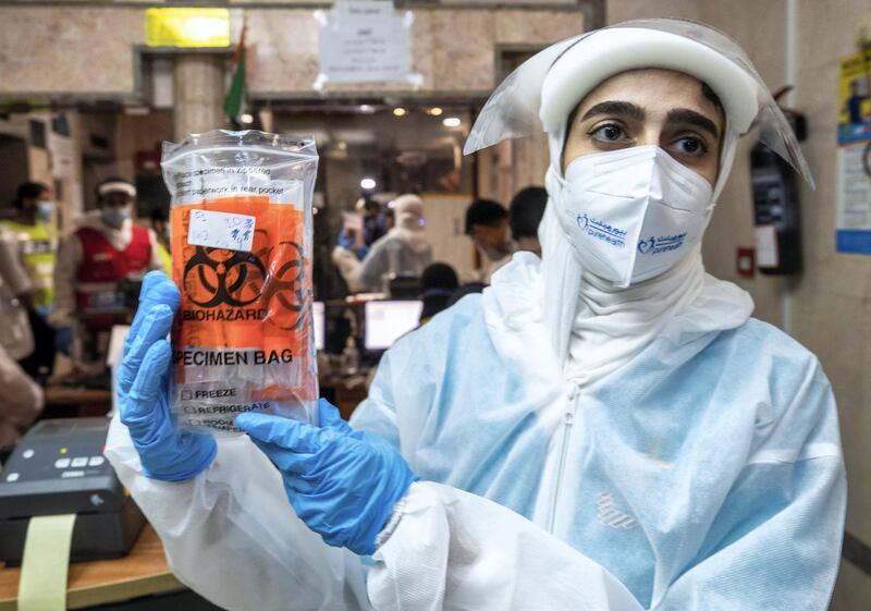 Abu Dhabi, United Arab Emirates, June 22, 2020.   
STORY BRIEF: Police patrols knocking on doors offering free Covid-19 tests to residents in buildings in AD downtown, Al Bakra Street area.
--  Healthcare workers collecting and labeling samples of the residents.
Victor Besa  / The National
Section:  NA
Reporter:  Haneen Dajani