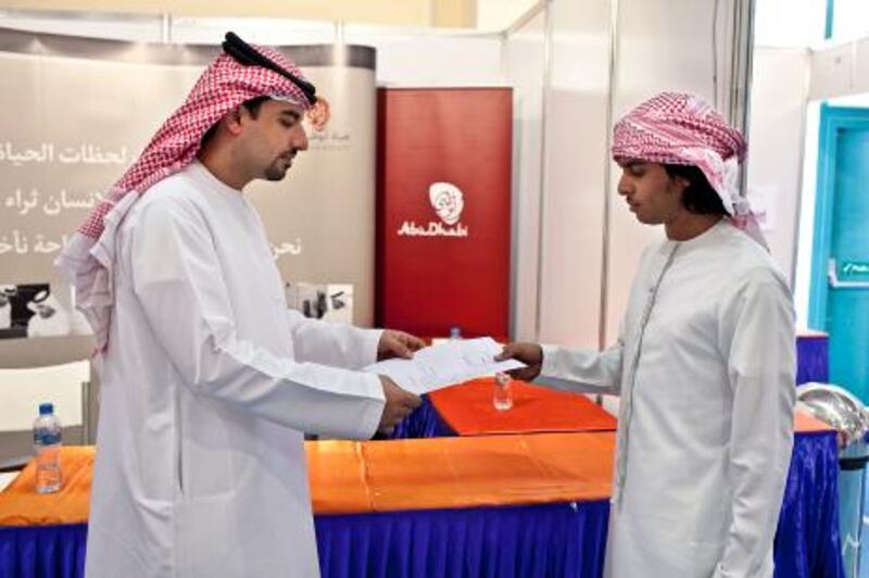 At right, Turki al Rashdi, 21, talks with Mohamed al Marzouqi, left, a senior Tourism Industry Emiratisation Executive from the Abu Dhabi Tourism Authority at the Al Gharbia Careers Fair on Wednesday, Nov. 23, 2011 at the Higher Colleges of Technology campus in Ruwais. Al Rashdi applied in hospitality sector. (Silvia Razgova/The National)

