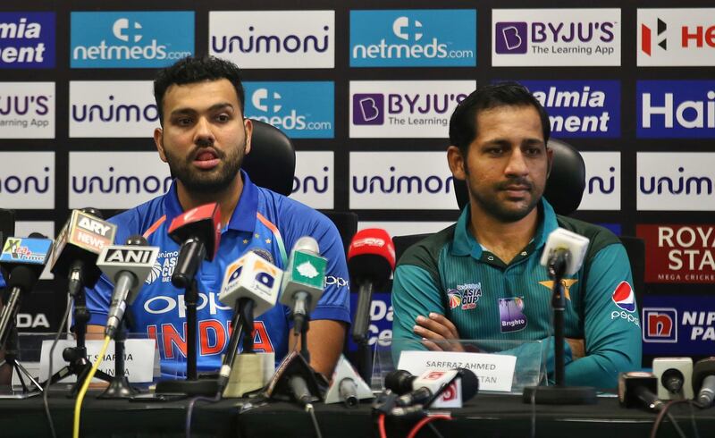 Captains of India Rohit Sharma, left, and Pakistan Sarfraz Ahmed listen to a question from a journalist during a press conference ahead of Asia Cup cricket at Dubai International Cricket Stadium in Dubai, United Arab Emirates, Friday, Sept. 14, 2018. (AP Photo/Aijaz Rahi)