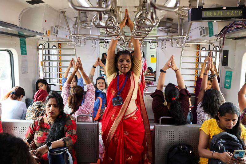 Women practice yoga during a train journey in Mumbai to mark International Women's Day. Reuters
