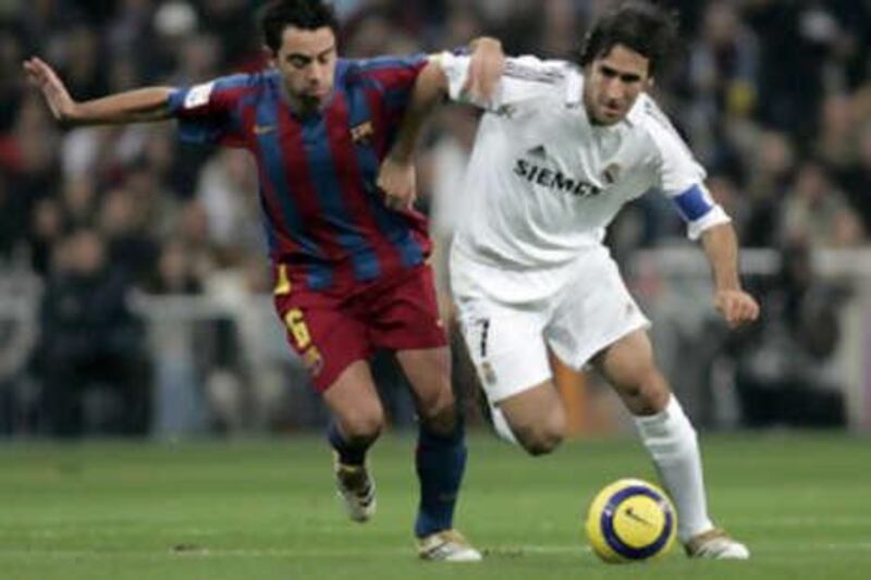 Raul, right, and Xavi fight for the ball during an El Clasico game. The rivalry is oneof the longest-running in Spanish football.