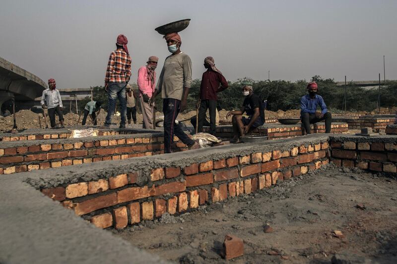 Workers construct funeral pyre plinths on barren land near a crematorium in New Delhi, India. Bloomberg