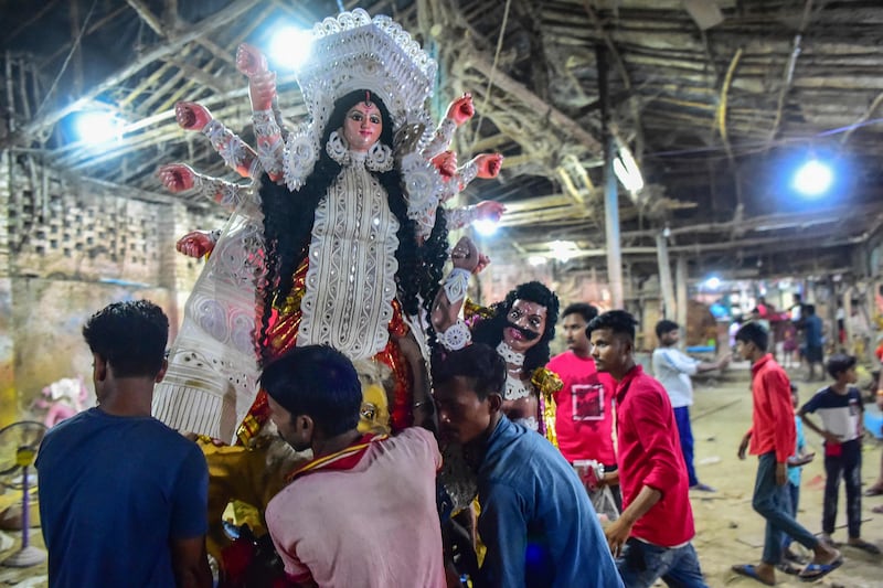 Devotees carry a clay idol of Durga at a workshop during the Navratri festival in Allahabad. AFP