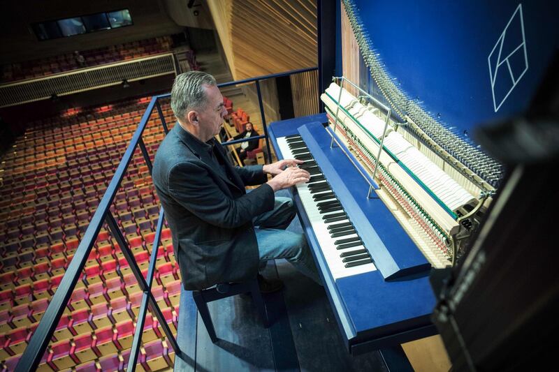 Piano constructor and builder David Klavins plays his new creation, the M470i vertical concert grand piano. AFP