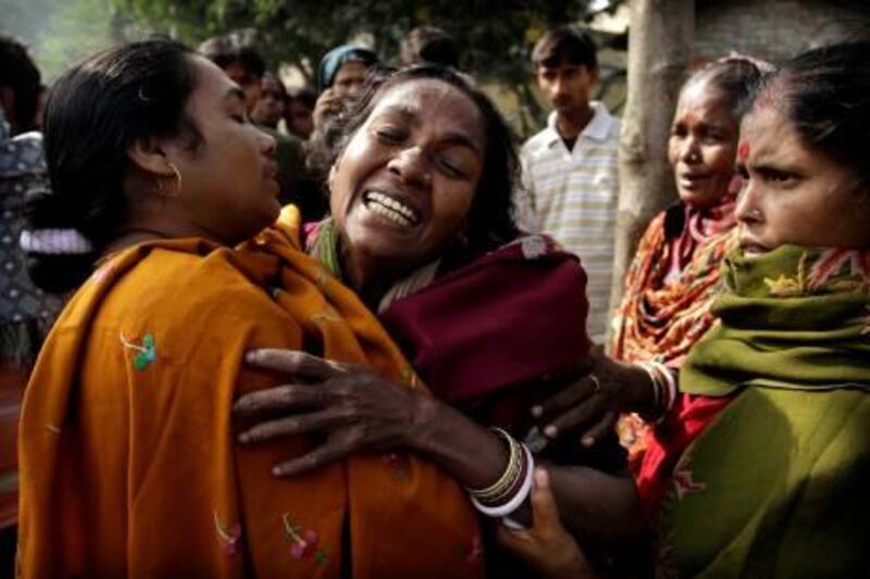 An Indian woman is comforted as she cries after hearing her relative's death from toxic alcohol outside a hospital in Diamond Harbour, near Kolkata, India, Thursday, Dec. 15, 2011. A tainted batch of bootleg liquor has killed scores and sent dozens more to the hospital in villages outside Kolkata, officials said.(AP Photo/Bikas Das) *** Local Caption ***  India Liquor Deaths.JPEG-09d17.jpg