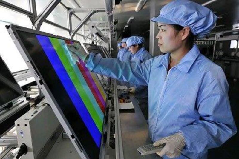 Employees clean and test newly made LED TV screens at a factory in Rizhao, China. Reuters