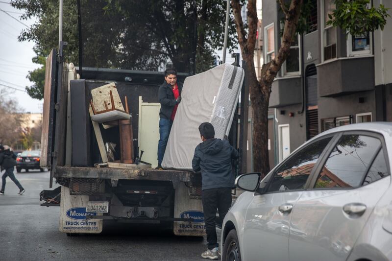 Workers remove damaged items from a shop flooded during a rainstorm in San Francisco. Bloomberg