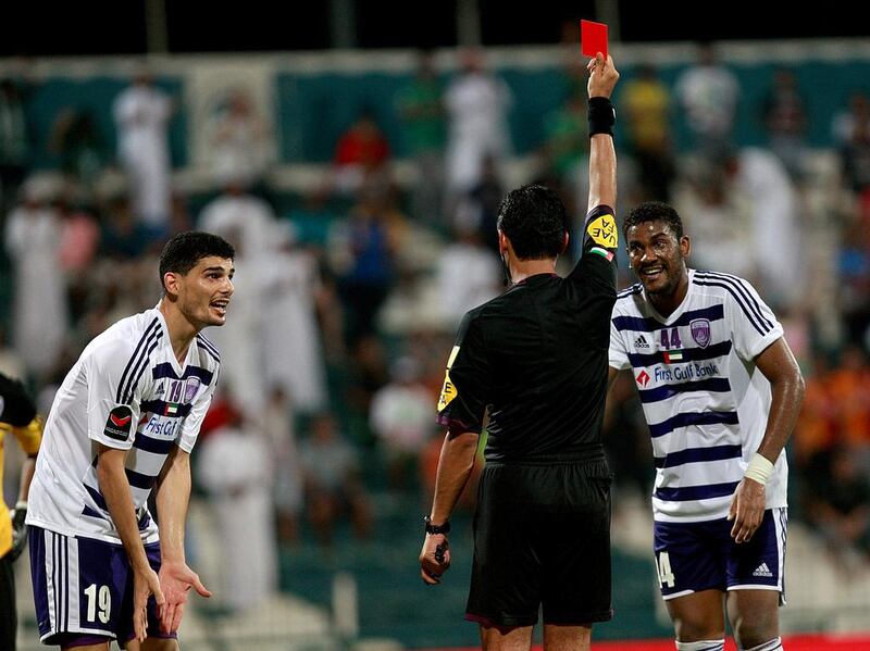 Mohanad Salem, left, is shown a red card by the referee last night as Al Ain’s troubles continued on the pitch against Al Shabab. Satish Kumar / The National