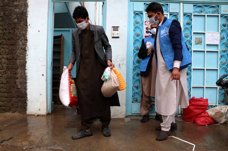 Afghan men receive free rations distributed in Herat, Afghanistan, on March 24, 2020. EPA