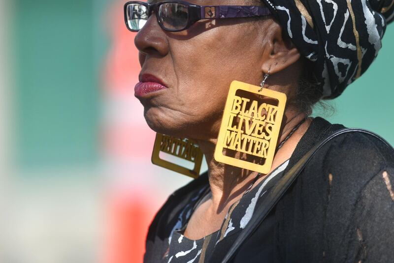 A woman wears black lives matter earrings while waiting in line to enter Stephon Clark's funeral in Sacramento, California. Josh Edelson / AFP Photo