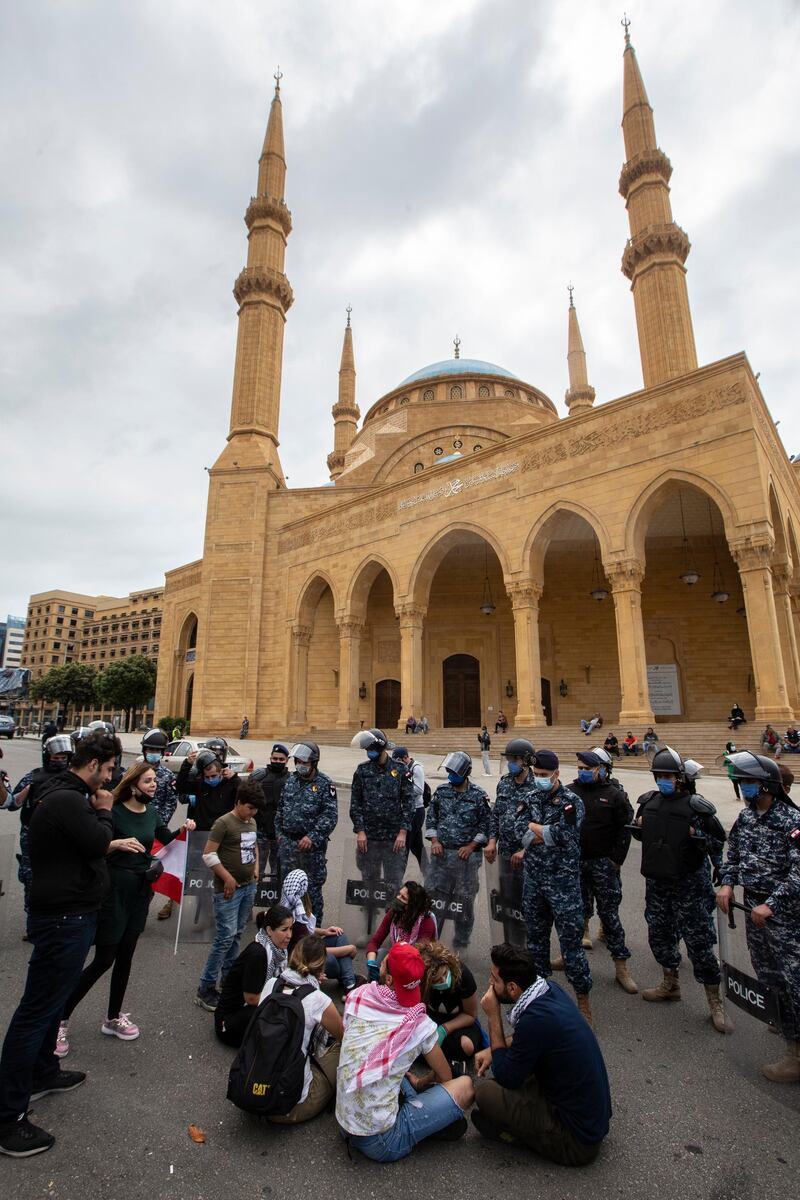 Anti-government protestor shouts slogans in front Lebanese police officers as they try to close the road in front Al-Ameen mosque during a protest against the collapsing Lebanese pound currency and the price hikes of goods, in Beirut, Lebanon.  EPA