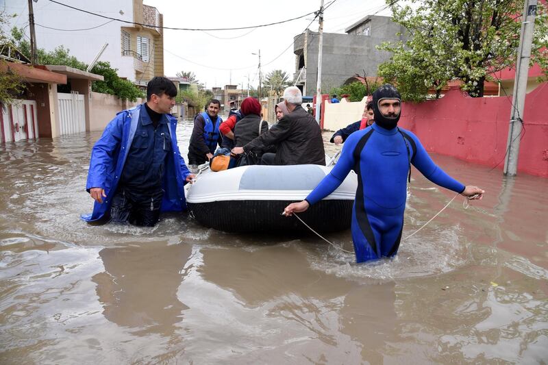 Members of civil defense evacuate Iraqis after their house was flooded due to heavy rains in Mosul city, northern Iraq. EPA