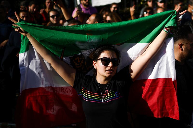 A woman holds a flag, as people protest against the Iranian regime outside Iran's embassy in central London. Reuters