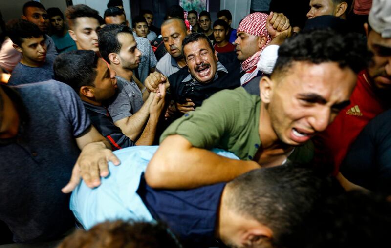TOPSHOT - Palestinian relatives react as they arrive at the morgue of the al-Shifa hospital in Gaza City where the body of Mohammed Badwan was brought after he was shot dead by Israeli forces during protests along the border east of Gaza City. / AFP / ANAS BABA
