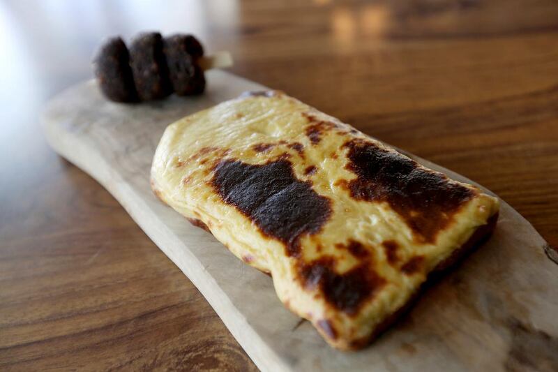 Welsh rarebit with caramelised onion under a layer of toasted Montgomery's Cheddar, with a side of vegetarian black pudding. Pawan Singh / The National