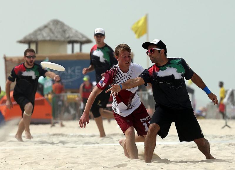 Qatar (White) and UAE (Black) in action during the 2015 World Championships of Beach Ultimate (WCBU) at the JBR beach in Dubai. Satish Kumar / The National