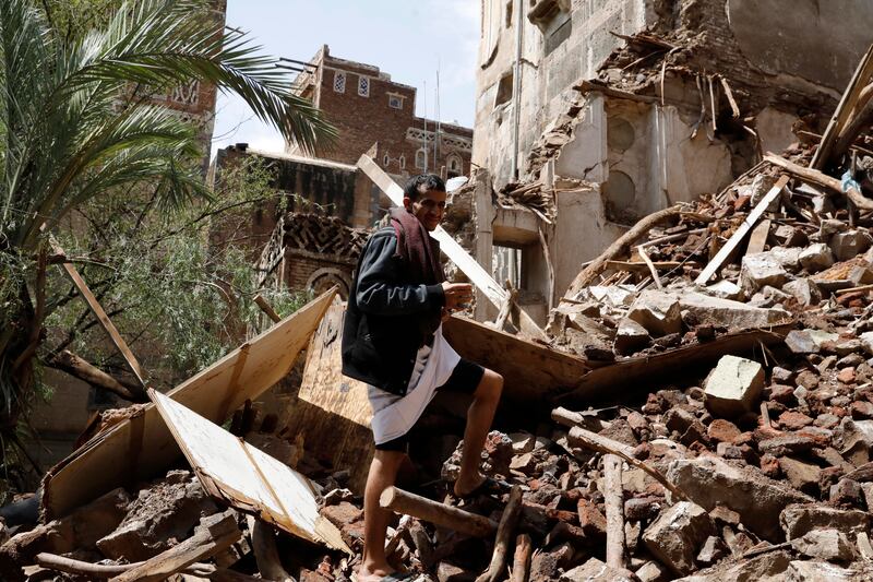A Yemeni man inspects a collapsed building in the old quarter of Sanaa. EPA 