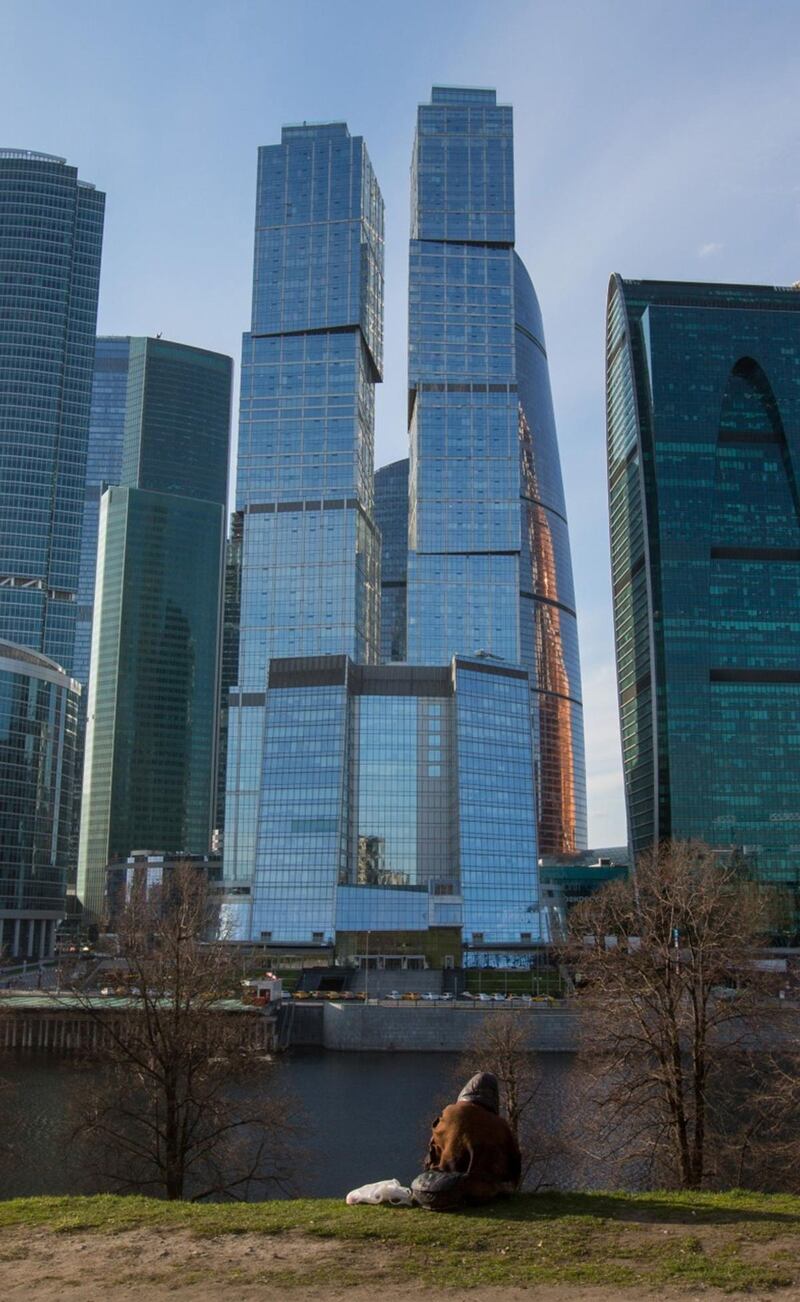 A pedestrian sits on the bank of the Moscow River in view of City of Capitals in the Moscow International Business Center (MIBC), also known as Moscow City, in Moscow, Russia, on Tuesday, April 28, 2020. Russia has reported 93,558 confirmed Covid-19 cases. Photographer: Andrey Rudakov/Bloomberg