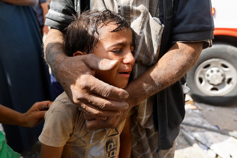 A Palestinian boy cries following Israeli strikes on houses in Rafah. Reuters