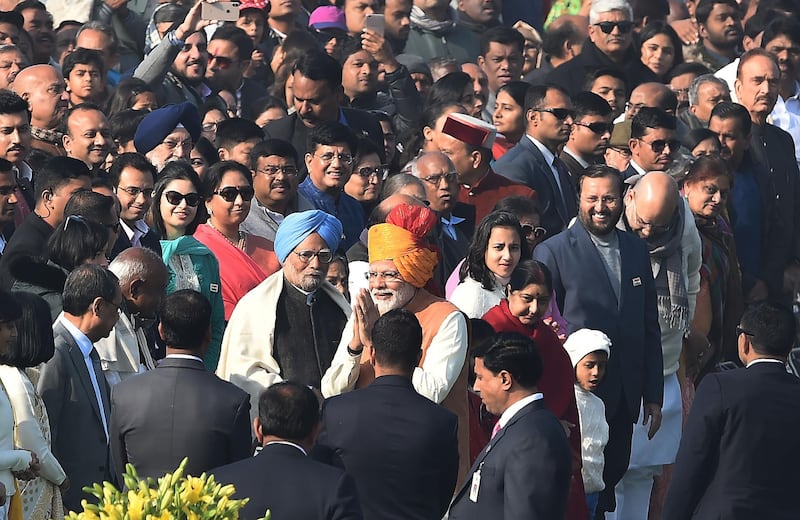 Indian Prime Minister Narendra Modi gestures as he walks past former Indian Prime Minister Manmohan Singh (in blue turban) ahead of the 70th Republic Day parade in New Delhi.  AFP