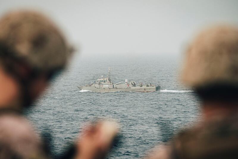 Marines onboard the ship USS John P Murtha observe an Iranian fast attack craft as it transits the Strait of Hormuz, off Oman. Reuters