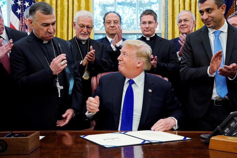 Archbishop Bahar Matti Warda, Archbishop of Erbil and the Chaldean Catholic Archeparchy of Erbil, holds the pen given to him by U.S. President Donald Trump after he used it to sign the Iraq and Syria Genocide Relief and Accountability Act of 2018 in the Oval Office at the White House in Washington, U.S. December 11, 2018.  REUTERS/Jonathan Ernst     TPX IMAGES OF THE DAY