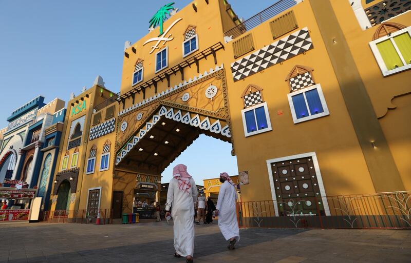 Two Saudi Arabians walk past their country's pavilion at the Global Village in Dubai. EPA