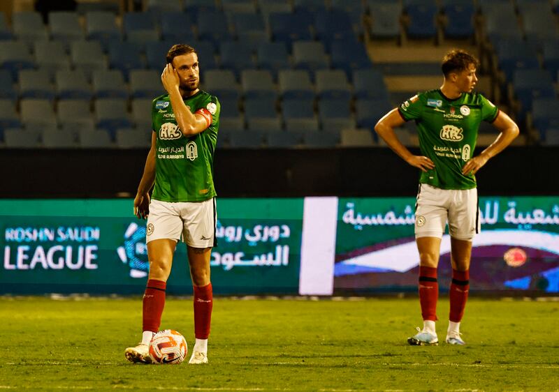 Al Ettifaq midfielder Jordan Henderson, left, after Bernard Mensah scored Al Tai's third goal. Reuters