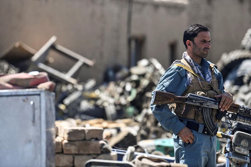 A policeman stands guard at a junkyard near the Bagram Air Base. AFP