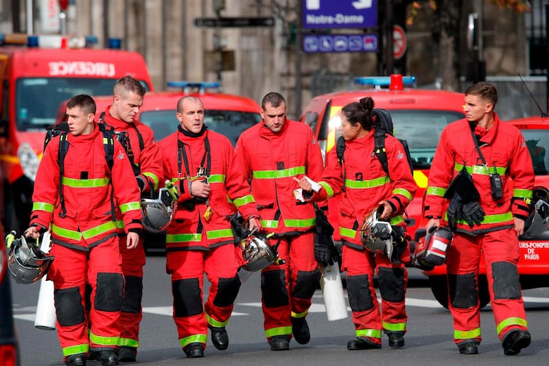 Firefighters walk near Paris prefecture de police. AFP