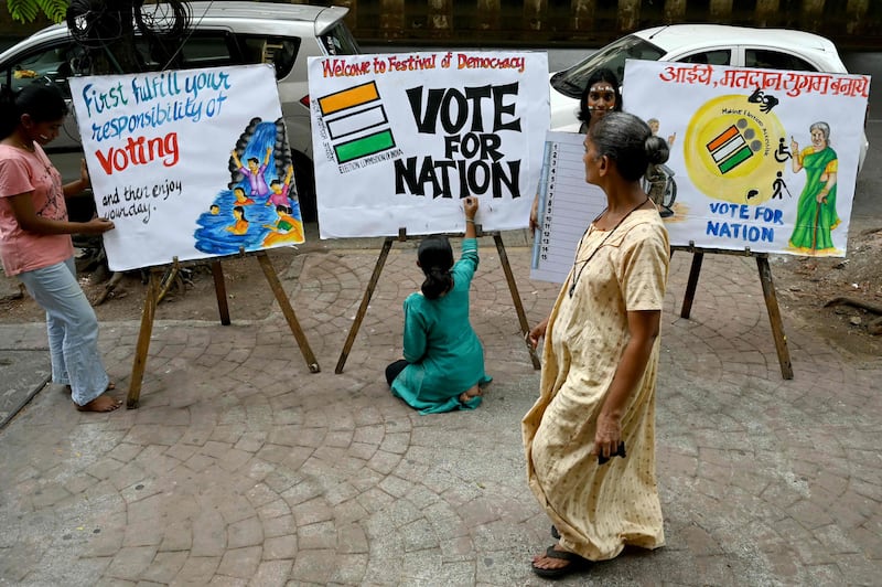 Students in Mumbai put the finishing touches to posters encouraging people to vote in India's general election, which begins on Friday. AFP