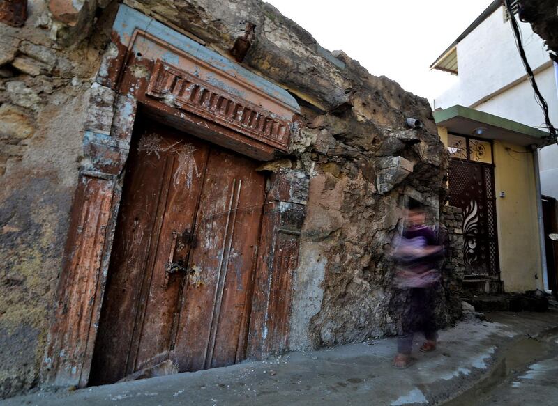 An Iraqi boy walks past a heavily-damaged house in the Old City of Mosul. AFP