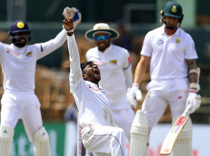 Sri Lankan cricketer Akila Dananjaya (2L) celebrates after he dismissed South African cricketer Dale Steyn (R) looks on during the second day of the second Test match between Sri Lanka and South Africa at the Sinhalese Sports Club (SSC) international cricket stadium in Colombo on July 21, 2018. / AFP / ISHARA S.  KODIKARA
