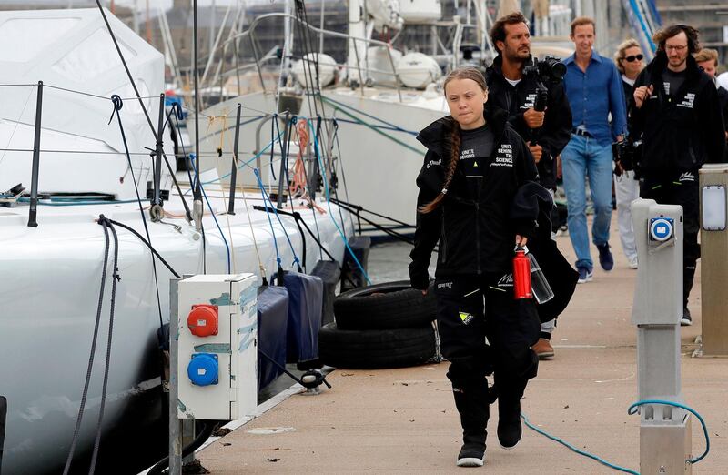 Swedish climate activist Greta Thunberg walks along the quayside to board. AFP