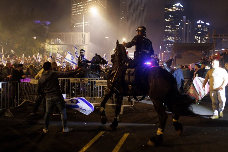 A mounted Israeli police officer clashes with demonstrators on the Ayalon motorway during the anti-government protests. Bloomberg