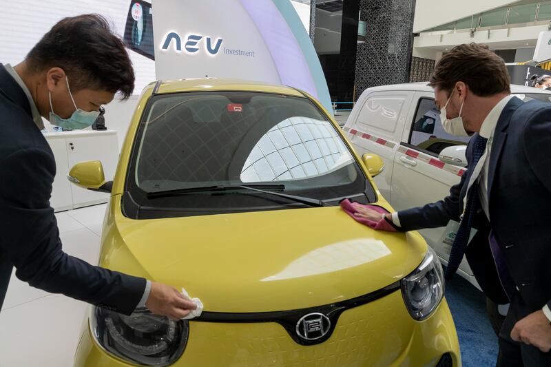 Visitors check out an electric vehicle at the show.
