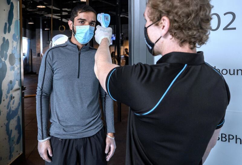 Abu Dhabi, United Arab Emirates, July 1, 2020. A gym member gets his temperature checked before entering Vogue Fitness Yas Marina, Abu Dhabi.
Victor Besa  / The National
Section:  NA 
Reporter:  Haneen Dajani