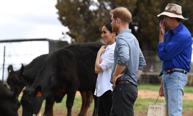 Britain's Prince Harry and his wife Meghan, Duchess of Sussex, chat with farmer Scott Woodley during a visit to his family's drought-affected farm called Mountain View near Dubbo on October 17, 2018.  AFP