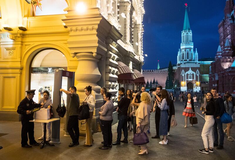 People are checked by security guards before entering GUM, State Shop, at Red square in Moscow, Russia, Wednesday, Sept. 13, 2017. Heavy security was in place in central Moscow outside the flagship department store GUM following a bomb threat. GUM was one of dozens of major buildings, including shopping centers, railways stations, hotels and universities, in the Russian capital targeted on Wednesday by anonymous telephone hoaxers. (AP Photo/Pavel Golovkin)