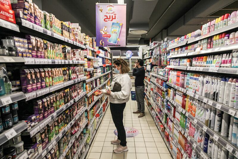 Shoppers browse products inside a supermarket.