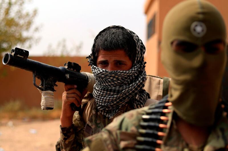 Members of the Syrian Democratic Forces (SDF) gather next to a building in the village of Susah in the eastern province of Deir Ezzor, near the Syrian border with Iraq. Delil souleiman / AFP