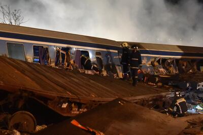 Firefighters work to extricate passengers from trains after the collision near Larissa. EPA
