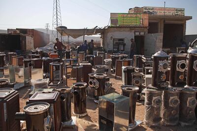 TOPSHOT - Pistachio-powered heaters are displayed for sale along a street in al-Dana town in Syria's northwestern province of Idlib on December 18, 2019. In recent months, Syria has suffered a fuel crisis that has seen a spike in the price of heating oil and long queues for much-demanded cooking gas in government-held parts of the country. The rising cost of heating fuel has made warm homes a luxury in a province where unemployment is high and public services are non-existent. / AFP / Aaref WATAD
