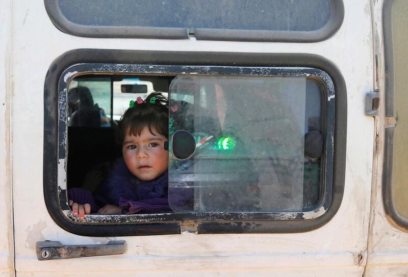 A child looks out of a window as Syrian refugees prepare to return to Syria from the Lebanese border town of Arsal, Lebanon, on June 28, 2018. Mohamed Azakir / Reuters